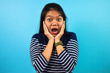 Mavi izole edilmiş geçmişi olan güzel Asyalı kadınların portresi, şok edici ifadeler gestur.