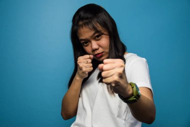 Genç Asyalı güzel kadınların portresi mavi izole edilmiş beyaz tişört kullanıyor.