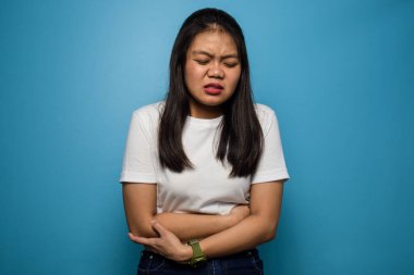 Genç Asyalı güzel kadınların portresi mavi izole edilmiş beyaz tişört kullanıyor.