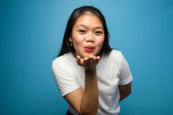 青の隔離された背景を持つ白いTシャツを使用した若い美しいアジアの女性の肖像画 — ストック写真