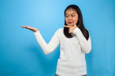 Genç ve güzel Asyalı kadınların portresi mavi izole edilmiş arka planı olan beyaz tişörtler kullanıyor.