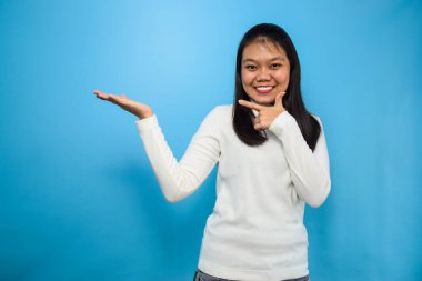 Genç ve güzel Asyalı kadınların portresi mavi izole edilmiş arka planı olan beyaz tişörtler kullanıyor.