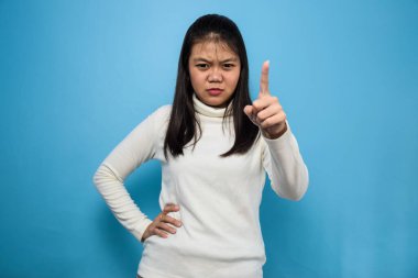 Asyalı güzel bir kadının portresi mavi izole edilmiş beyaz tişört giyiyor.