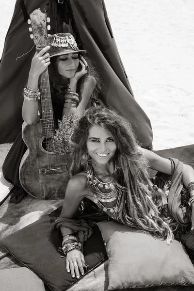 테페에서 베개에 앉아 기타와 함께 두 명의 아름 다운 집시 소녀 스톡 사진