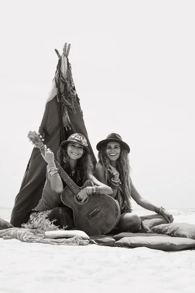 테페에서 베개에 앉아 기타와 함께 두 명의 아름 다운 집시 소녀 스톡 사진
