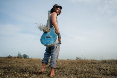 Çekici genç boho adam açık havada gitar ile