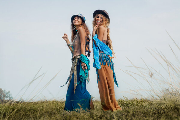 Two beautiful boho girls in ethnic jewelry outdoors