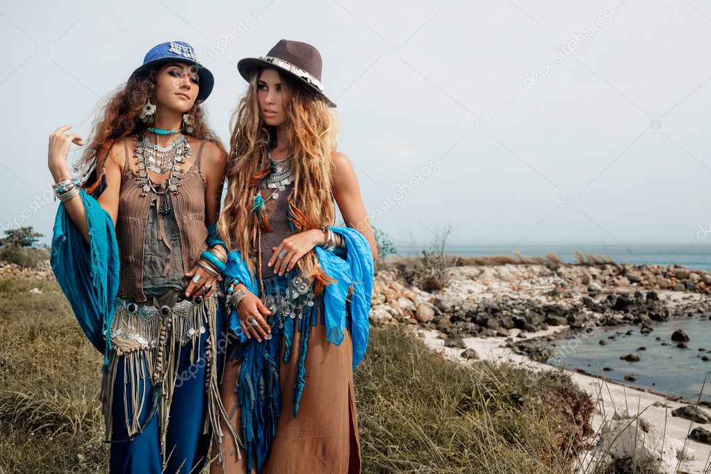 Two beautiful boho girls in ethnic jewelry outdoors