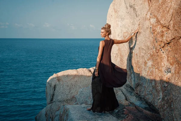 石と空の背景と屋外の魅力的な若い女性 — ストック写真