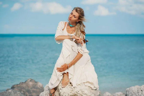 Bela mulher boho em pedra na costa do mar — Fotografia de Stock