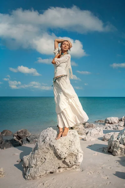 Красивая женщина на камне у морского берега — стоковое фото