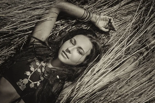 Schöne junge Boho-Frau im Gras liegend — Stockfoto