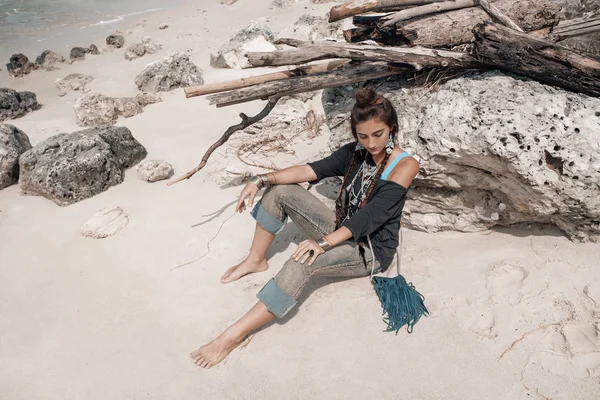 Piękna młoda kobieta siedzi na plaży — Zdjęcie stockowe