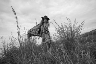 Panço yeşil sahada günbatımında giyen güzel boho kadın