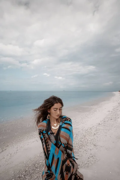 Bella giovane donna che indossa poncho camminare sulla spiaggia — Foto Stock