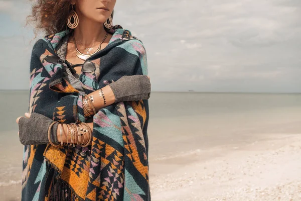 Wanita muda cantik mengenakan poncho di pantai — Stok Foto