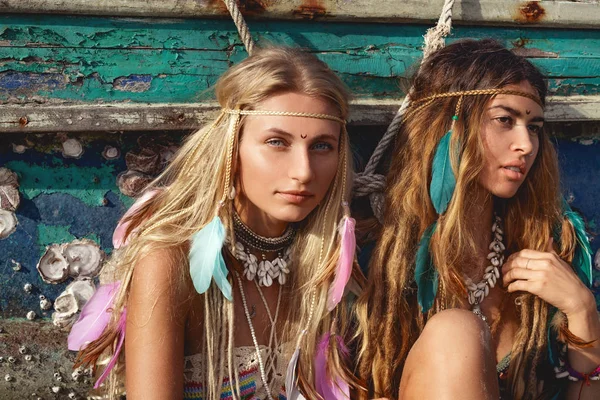 Deux belle jeune femme en bikini assis sur la plage à vieux bateau de pêche — Photo