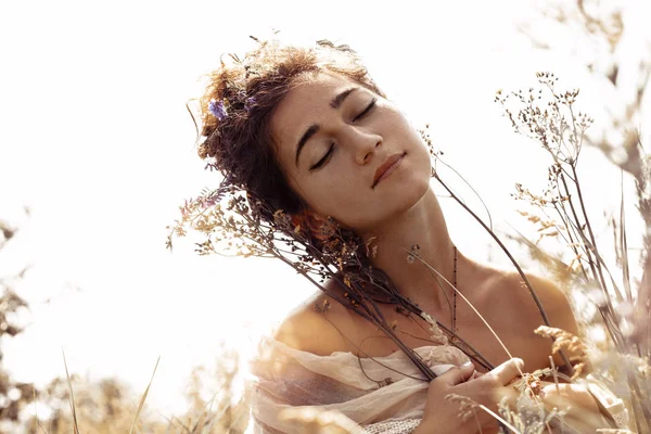 Красивая молодая женщина с закрытыми глазами на поле на закате — стоковое фото