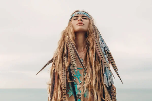 Fashion model portrait outdoors. boho style young woman with headdress made of feathers — Stock Photo, Image