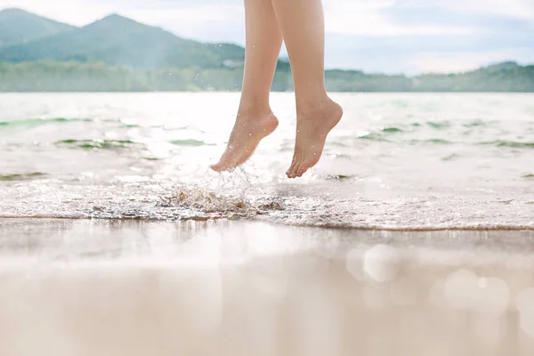 女人腿跳波在海滩上的特写 — 图库照片