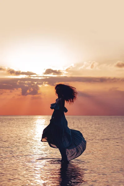 Elegant woman dancing on water. Sunset and silhouette — Stock Photo, Image