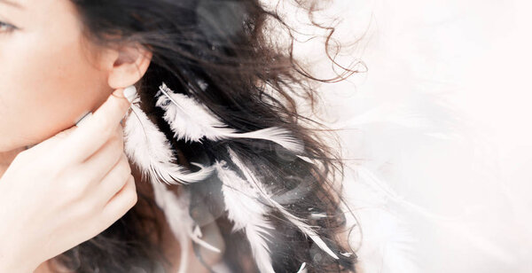 close up portrait of beautiful woman with white feathers