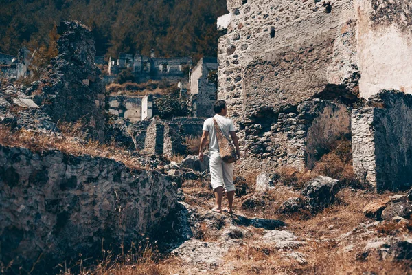 Jongeman reiziger in oude ruïnes van de stad — Stockfoto