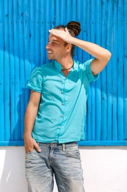 neşeli genç adam resme mavi ahşap duvar arka plan