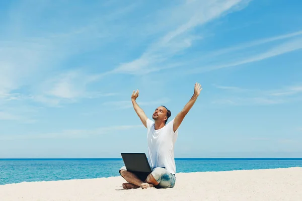 Ung man med laptop på stranden — Stockfoto