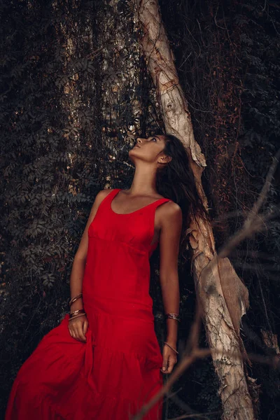 Attraente giovane donna in abito rosso nella foresta — Foto Stock
