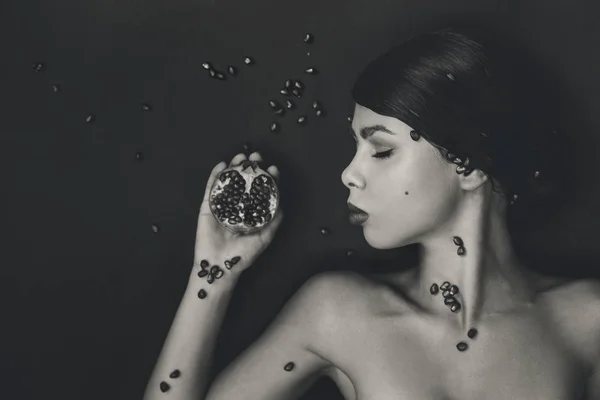 Close-up de atraente jovem mulher com romã em bac preto — Fotografia de Stock