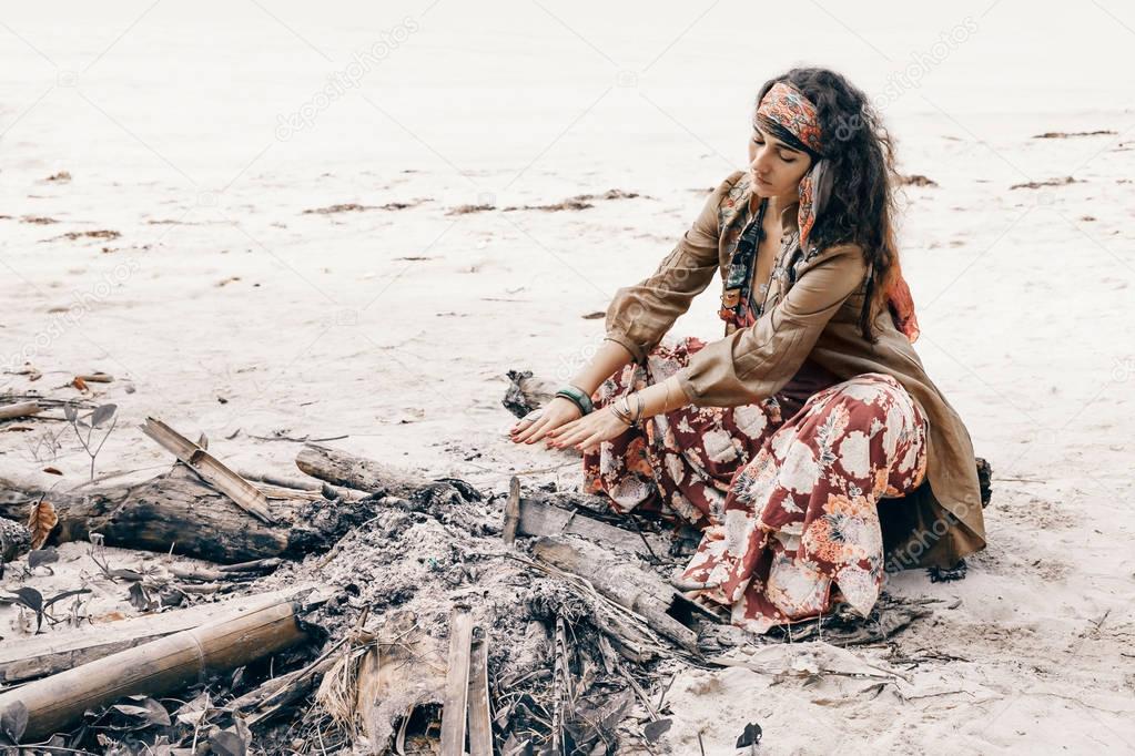 beautiful young gypsy style woman at fire