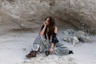 güzel genç boho tarzı kız moda model kum üzerine oturan