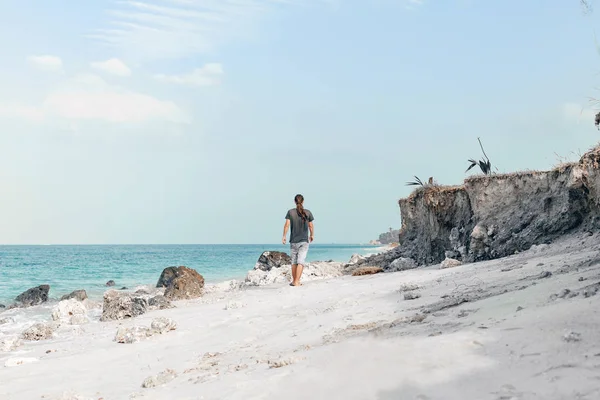 Joven guapo caminando por la playa — Foto de Stock