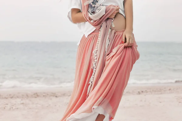 Belle jeune femme élégante en jupe rose sur la plage proche u — Photo