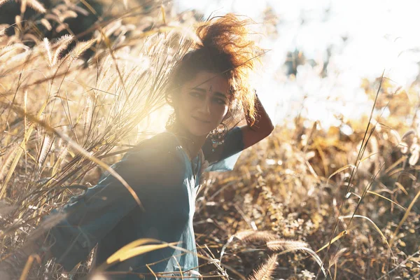 Joyeuse jeune femme sur un champ au coucher du soleil — Photo