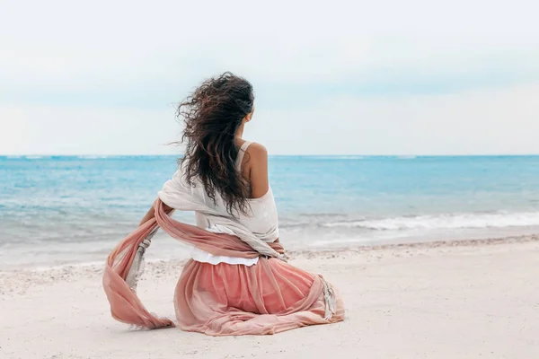 Όμορφη νεαρή γυναίκα κομψή σε ροζ φούστα στην παραλία — Φωτογραφία Αρχείου