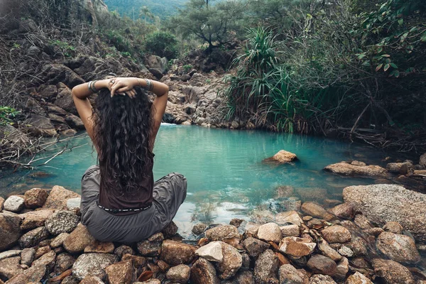 Jovem mulher sentada junto ao lago em selvas — Fotografia de Stock