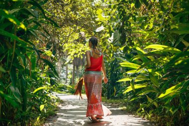 Tropica ile karayoluyla yürüyen neşeli genç boho tarzı kadın