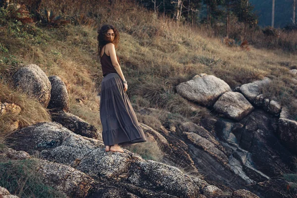 Gün batımında kaya üstünde güzel kadın — Stok fotoğraf
