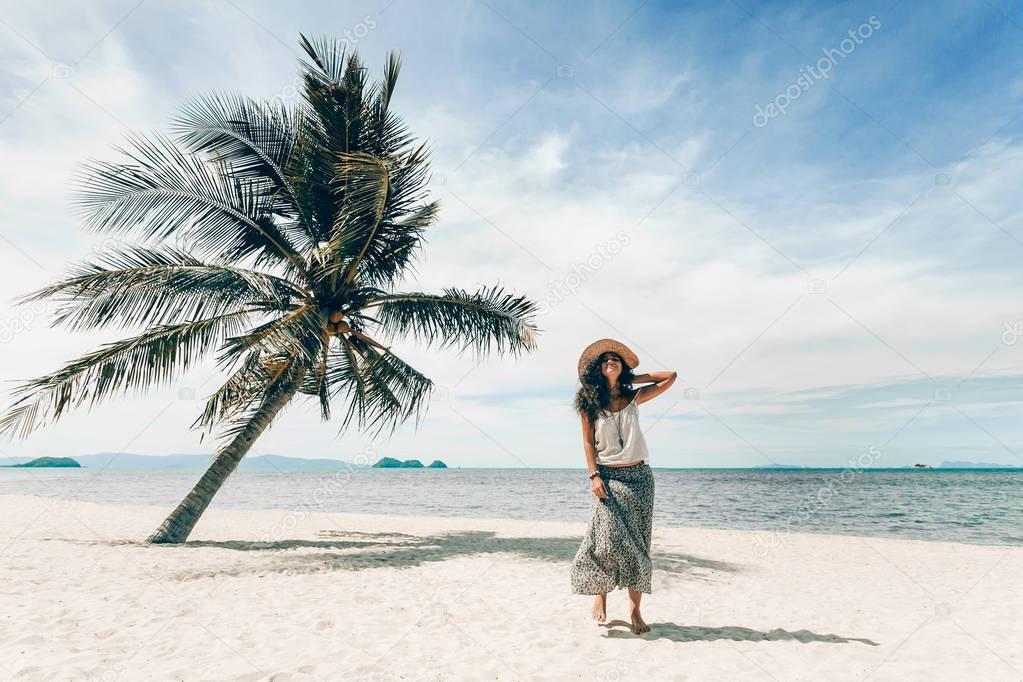 cheerful young woman having fun on tropical island beach