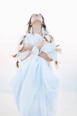 güzel genç boho kadın beyaz elbise ve poz tüyler