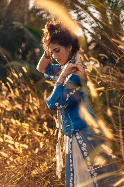 Hermosa joven en un campo al atardecer — Foto de Stock