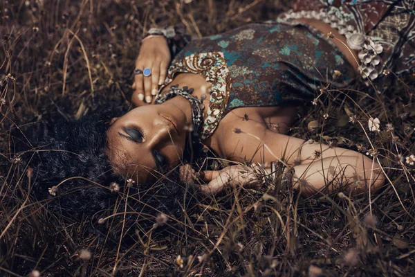 Όμορφη νεαρή κοπέλα Ανατολική σε εθνικές κοσμήματα ξαπλωμένος σε ένα γκρα — Φωτογραφία Αρχείου