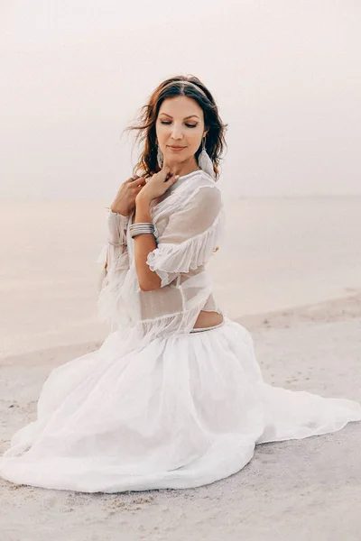 Hermosa joven y elegante mujer boho sentado en la playa — Foto de Stock