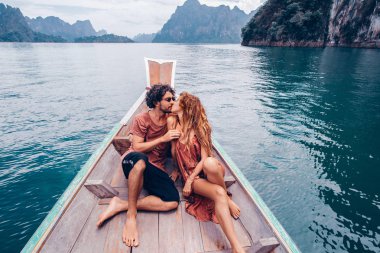 genç adam ve kadın turistler teknenin yay üzerinde oturan