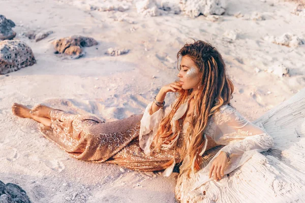 Schöne junge Frau in elegantem Kleid auf Sand liegend — Stockfoto
