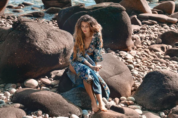 Piękna młoda kobieta w eleganckiej stylowej sukni na kamiennej plaży — Zdjęcie stockowe