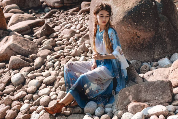 Hermosa mujer joven en elegante vestido elegante en la playa de piedra — Foto de Stock
