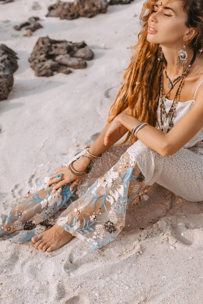 Beautiful young woman in elegant dress lying on sand — Stock Photo, Image